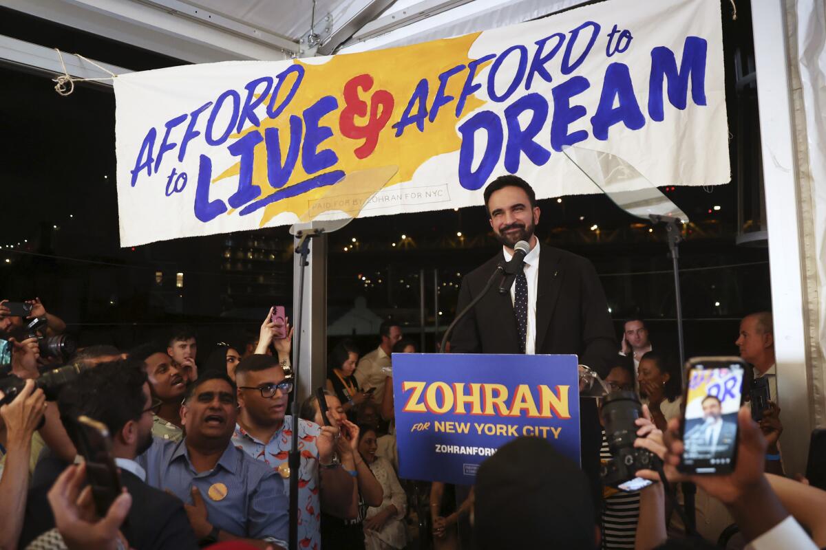 New York Democratic mayoral candidate Zohran Mamdani stands by a microphone.