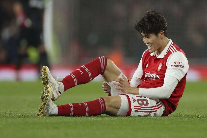 Arsenal's Takehiro Tomiyasu reacts after sustaining an injury during the Europa League round of 16, second leg, soccer match between Arsenal and Sporting CP at the Emirates stadium in London, Thursday, March 16, 2023. (AP Photo/Ian Walton)