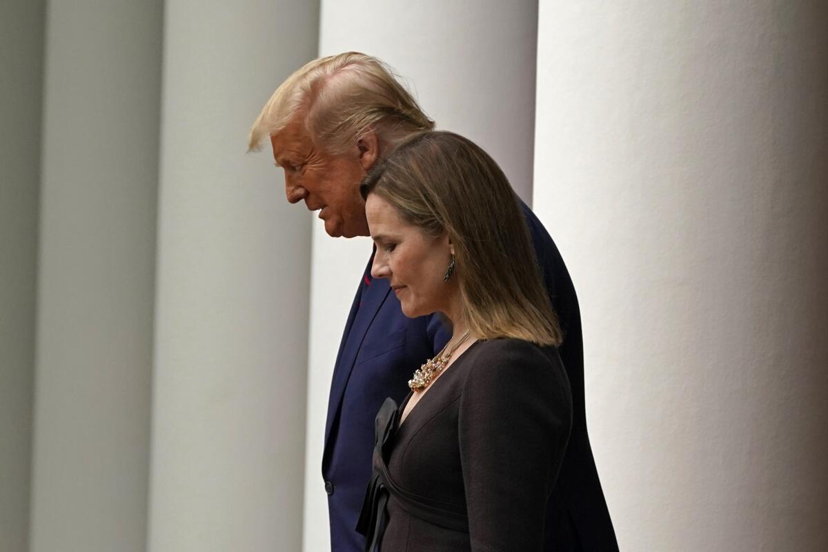 President Trump walks with Judge Amy Coney Barrett to a news conference at the White House on Saturday.