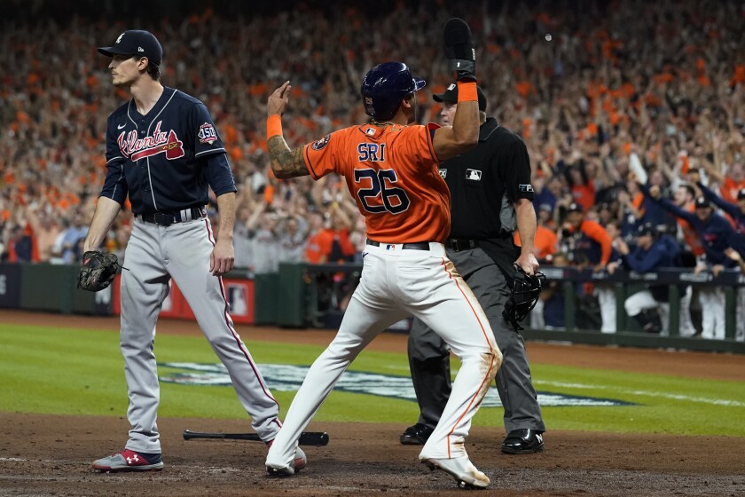 El dominicano José Siri, de los Astros de Houston, festeja junto al pitcher Max Fried, de los Bravos de Atlanta, luego de anotar en el segundo juego de la Serie Mundial, el miércoles 27 de octubre de 2021 (AP Foto/Eric Gay)