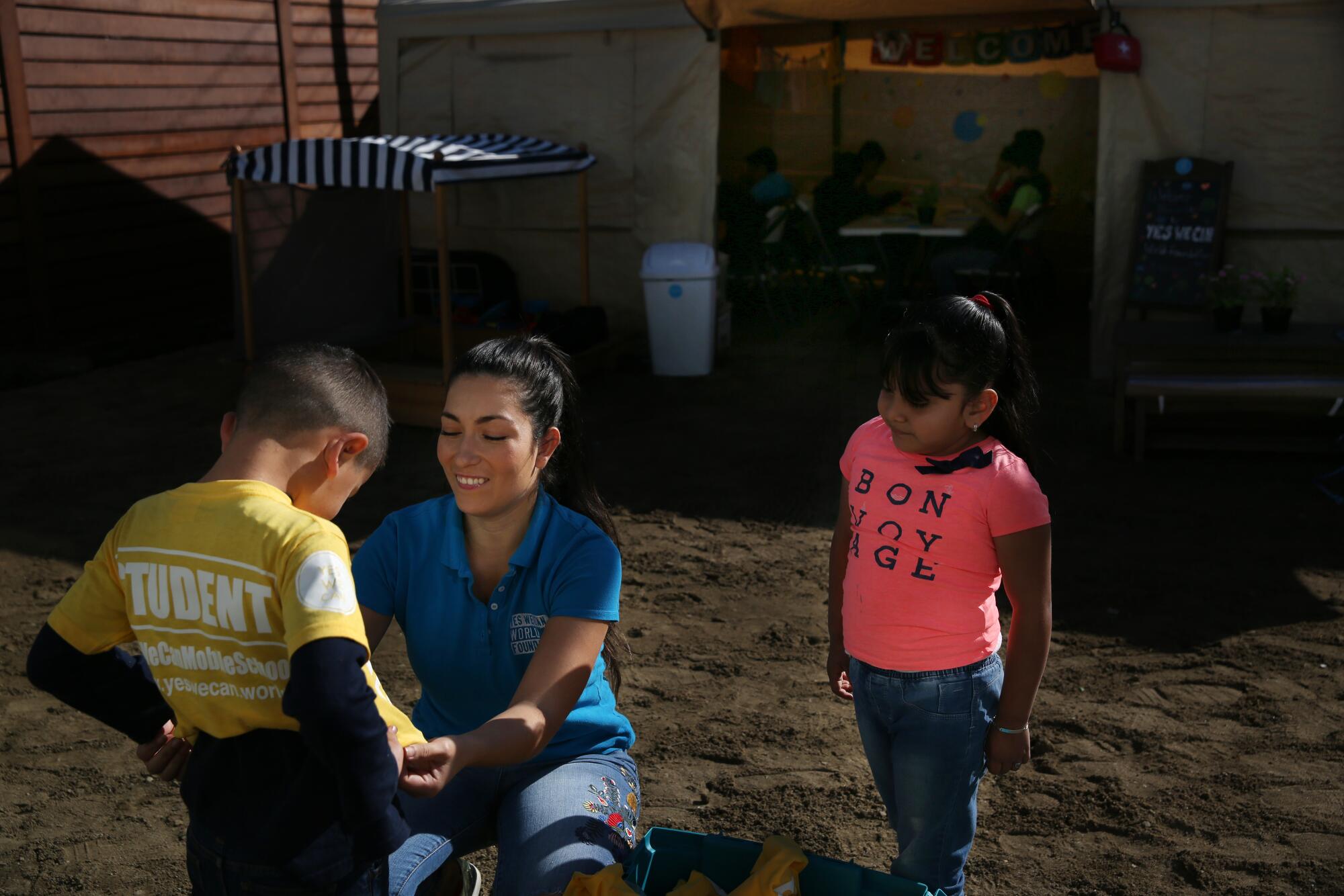 Estefanía Rebellón saluda a los nuevos estudiantes Fernando y Adriana y les entrega sus nuevos uniformes.