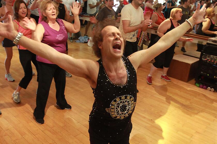 Richard Simmons sings along with the music as he teaches a class in Beverly Hills in 2013.