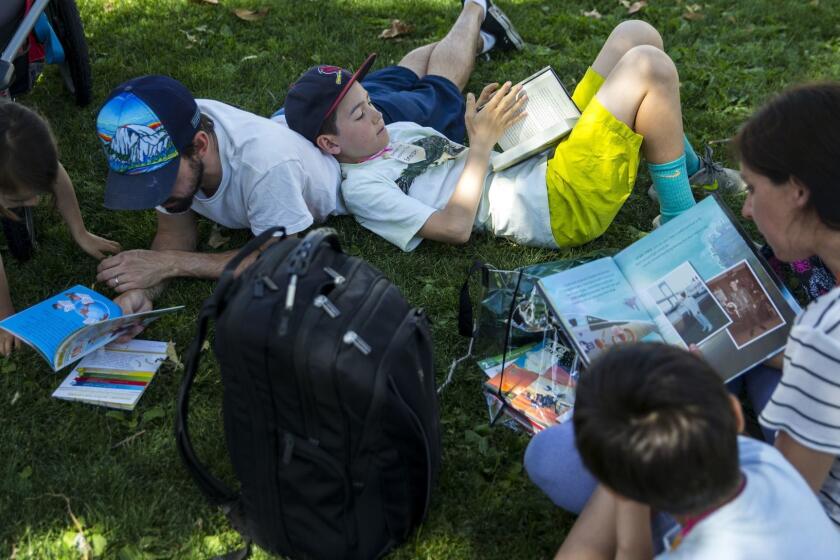 LOS ANGELES, CALIF. - APRIL 22: Aurora Carrillo-Vincent, 5, Matthew Carrillo-Vincent, 35, Emerson Carrillo-Vincent,11, Christine Carrillo-Vincent, 35, and Atticus Carrillo-Vincent, 7 , read together during the annual Los Angeles Times Festival of Books at the University of Southern California on Sunday, April 22, 2018 in Los Angeles, Calif. (Kent Nishimura / Los Angeles Times)