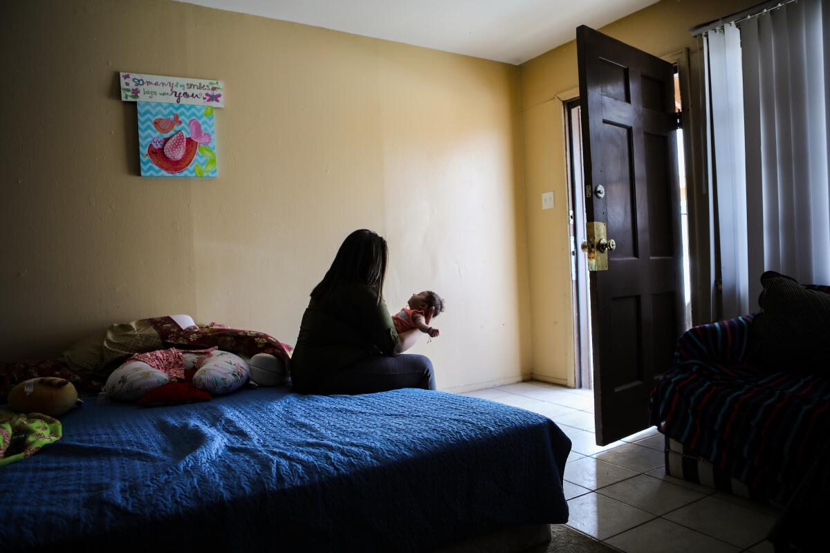 Luz holds her infant daughter while living in Las Cruces, N.M. 