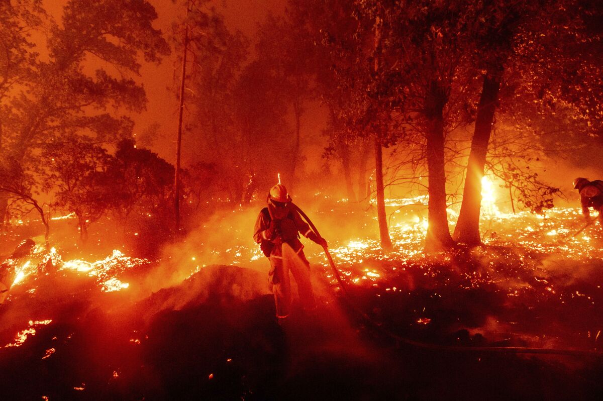 A firefighter battles the Creek fire as it threatens homes in the Cascadel Woods neighborhood in Madera County.