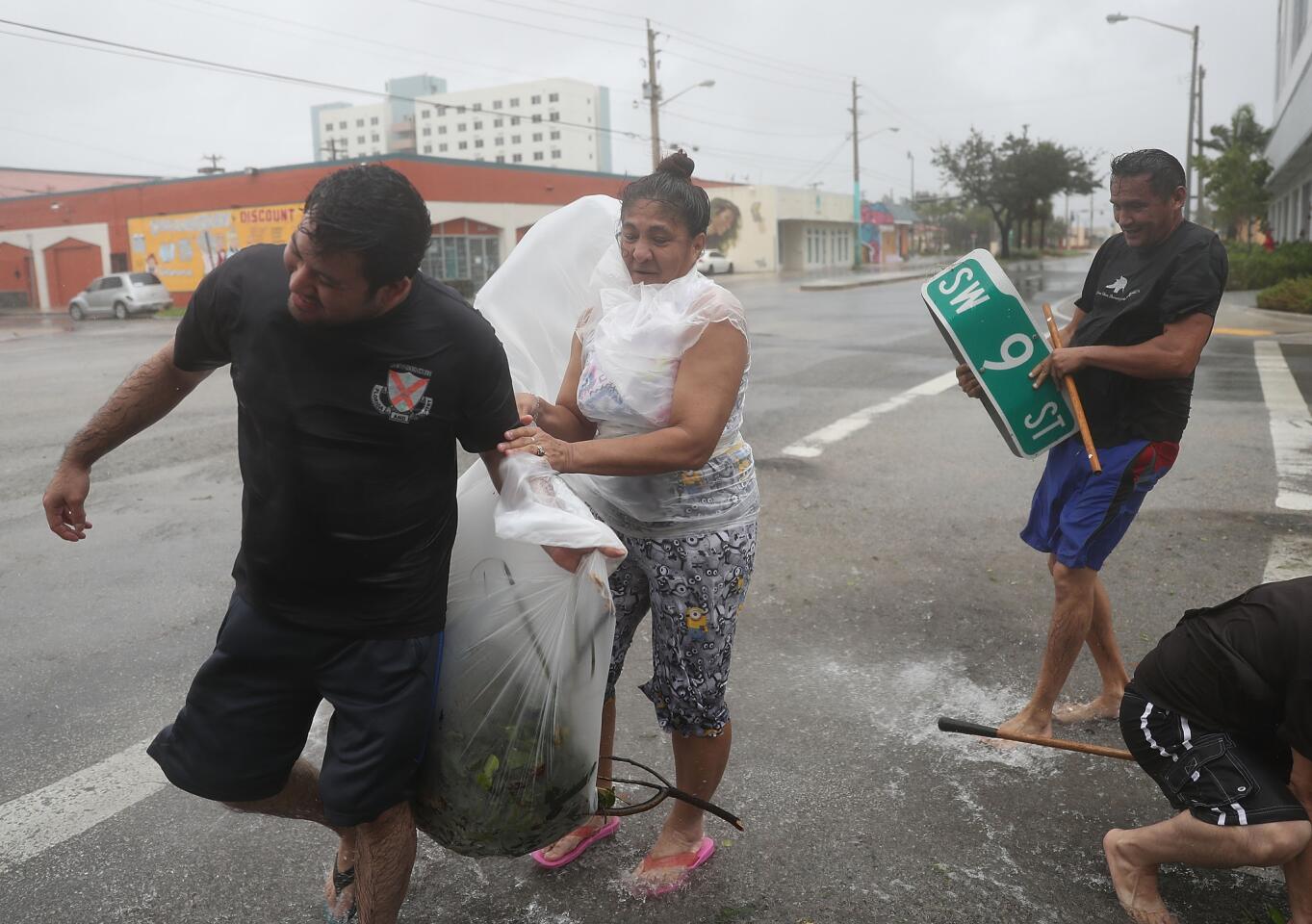 People clear debris out of a drainage ditch to keep the area from flooding as Hurricane Irma passes through Miami on Sept. 10, 2017.