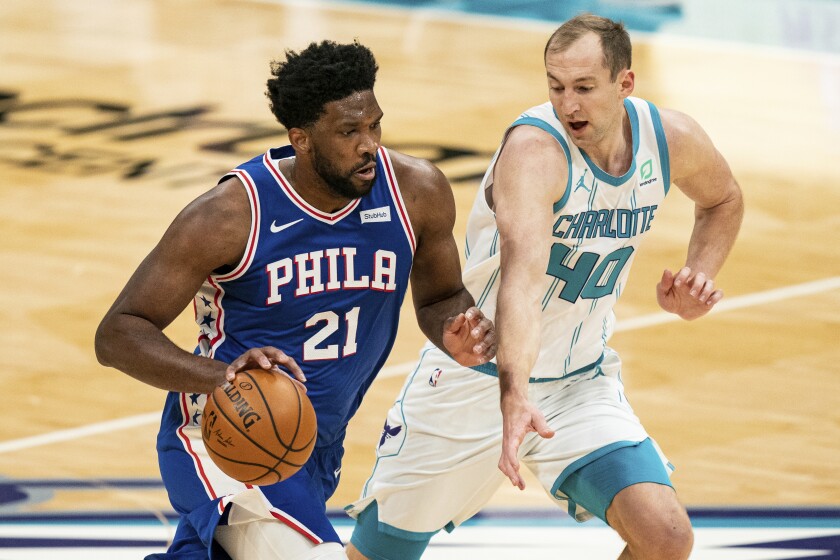 Philadelphia 76ers center Joel Embiid brings the ball up court while guarded by Charlotte Hornets center Cody Zeller.