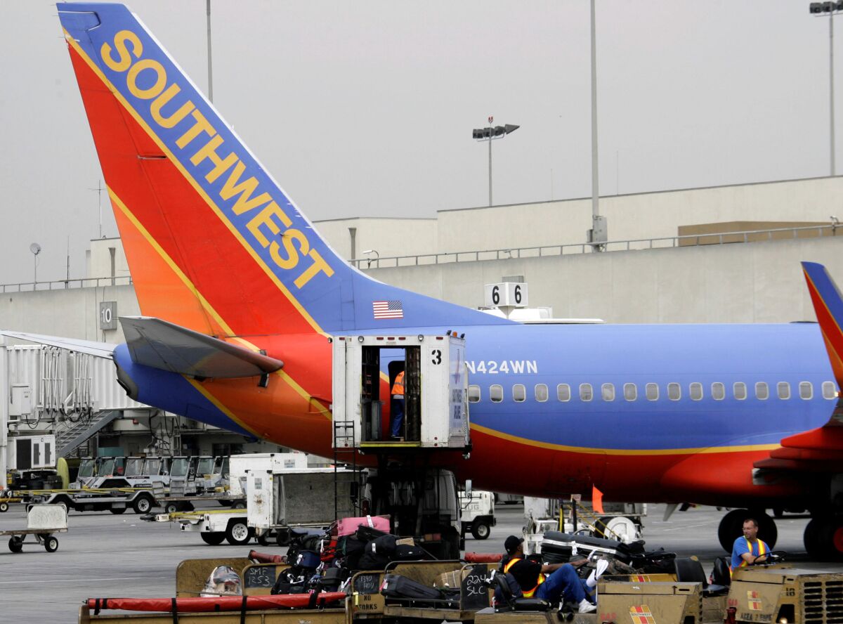 A Southwest Airlines plane is loaded with luggage at Los Angeles International Airport. Prosecutors announced Monday that three Southwest baggage handlers were among 14 people who circumvented airport security in order to smuggle drugs across the country.