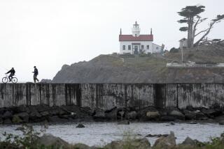 CRESCENT CITY, CA -- SEPTEMBER 18, 2019: Visitors walk along Lighthouse Way near the Battery Point Lighthouse and Museum, in the background. The 10-year plan for the Crescent City Harbor District, one of few economic engines in rural Del Norte County, is grim. The isolated area has an aging population. It's hard to get there. There's nothing to do. It's threatened by sea level rise. On top of it all, there's the threat of tsunamis, which wiped out the harbor in 2011. Crescent City has tried to make the best of a frustrating situation. (Myung J. Chun / Los Angeles Times)