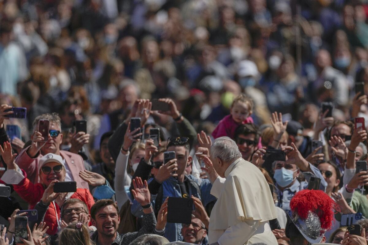 Pope Francis on his popemobile drives through the crowd of faithful at the end of the Catholic Easter Sunday mass he led in St. Peter's Square at the Vatican, Sunday, April 17, 2022. For many Christians, this weekend marks the first time in three years they will gather in person to celebrate Easter Sunday. (AP Photo/Alessandra Tarantino)
