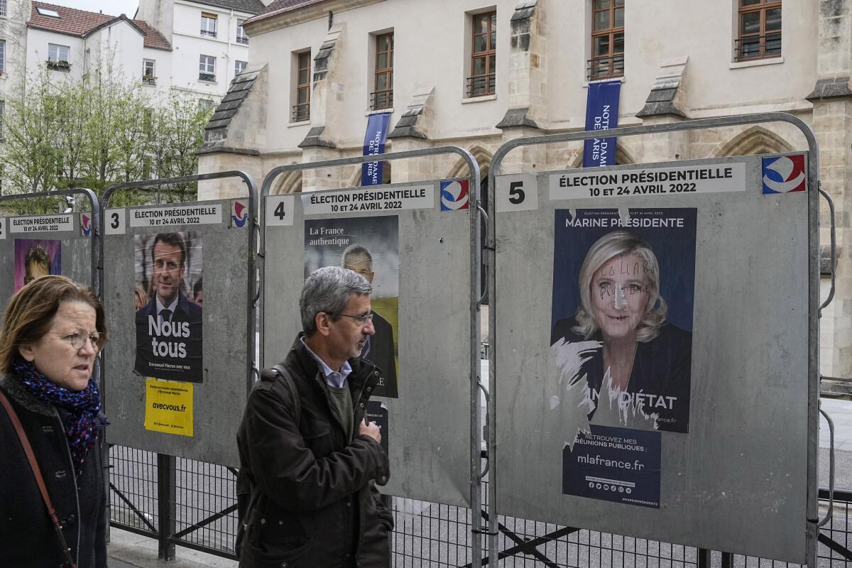 People walking past French presidential campaign posters