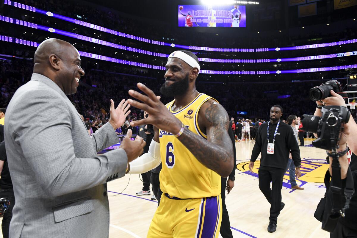 LeBron James hugs Magic Johnson after he passed Kareem Abdul-Jabbar to become the NBA's all-time leading scorer.