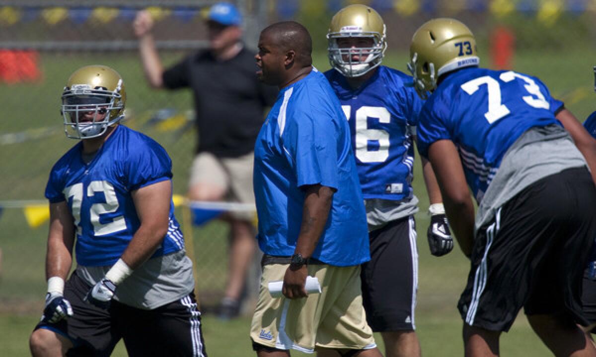UCLA offensive line coach Adrian Klemm works with players during a practice session in August 2012.