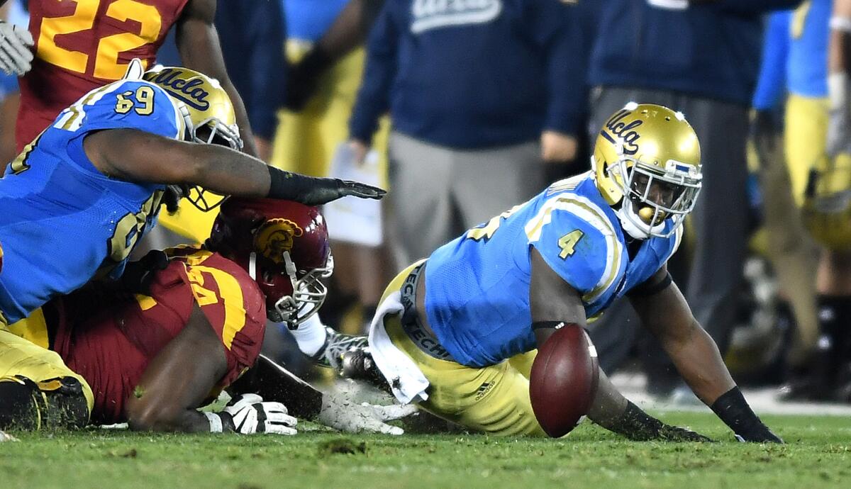 UCLA running back Bolu Olorunfunmi fumbles the ball against USC but would recover it in the second quarter on Nov. 19 at the Rose Bowl.