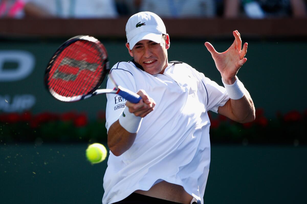John Isner returns a shot against Kevin Anderson during the BNP Paribas Open tennis in Indian Wells, Calif.