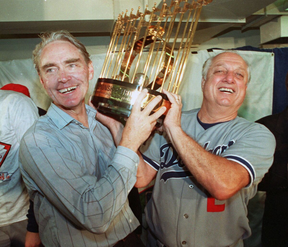 Fred Claire, Dodgers vice president, and Lasorda hoist the World Series trophy after their team's 1988 victory.