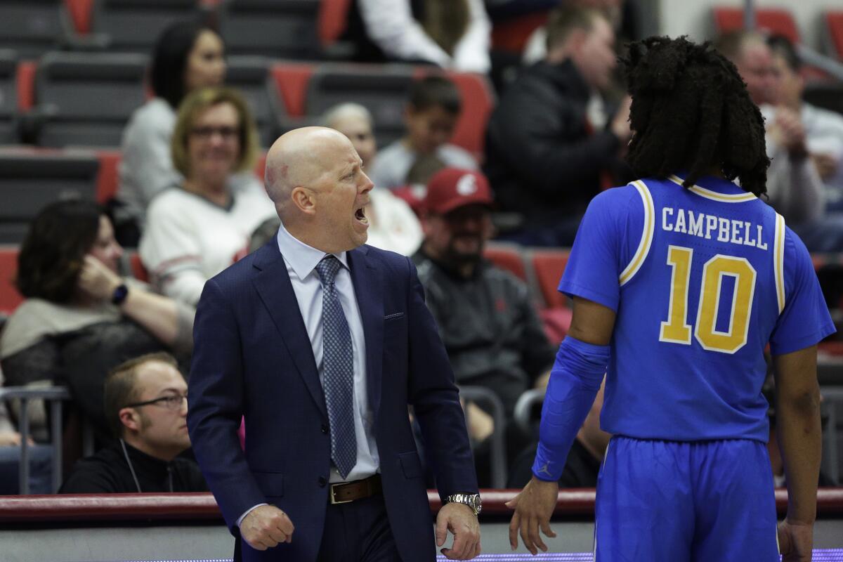 UCLA coach Mick Cronin, left, speaks with guard Tyger Campbell during a 67-66 win at Washington State on Dec. 30, 2022.