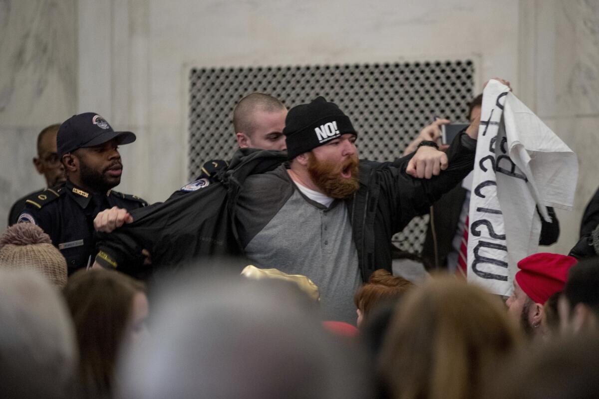 A protester is removed as he disrupts the Senate Judiciary Committee confirmation hearing for Atty. Gen.-designate, Sen. Jeff Sessions, R-Ala., as he testifies on Jan. 10, 2017, on Capitol Hill.