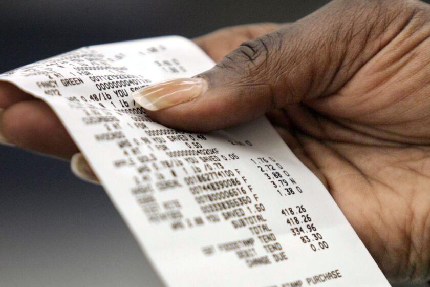 Laurie Palmer, of Portland, Ore., checks her sales receipt after checking out at Walmart.