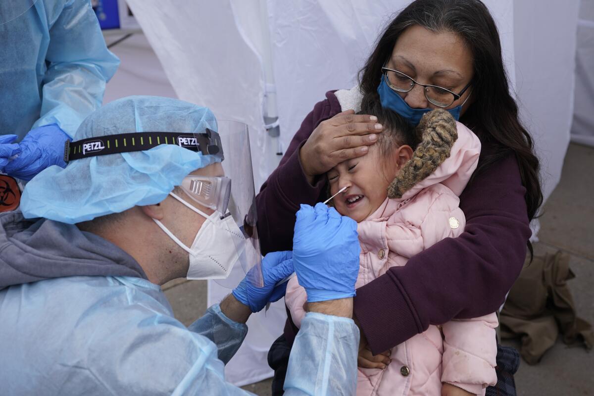 Kim Tapia holds granddaughter Amariah Lucero, 3, for a coronavirus test Tuesday in Salt Lake City.