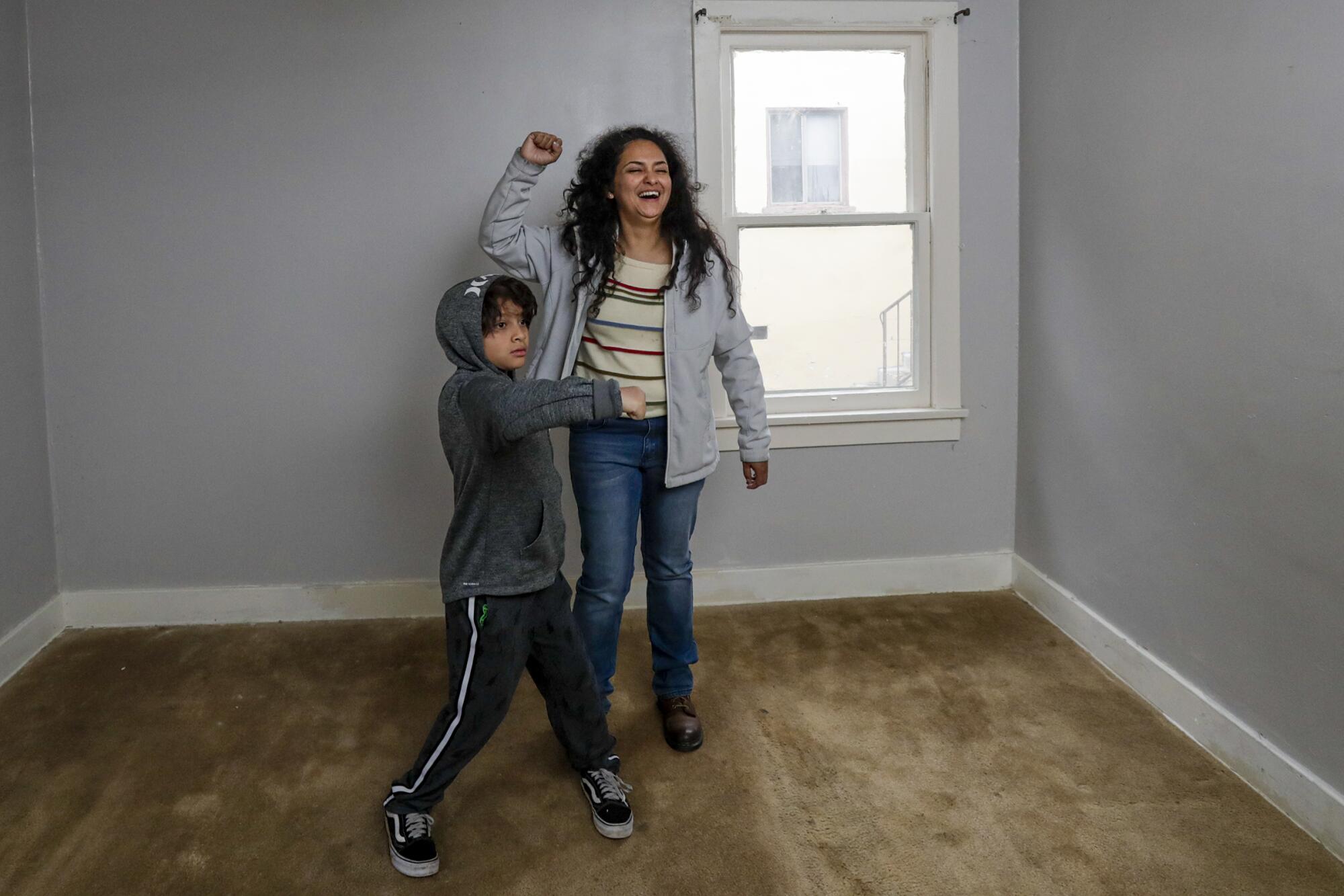 Ruby Gordillo and her 8-year-old son, Jacob, celebrate moving into a vacant house owned by the state in El Sereno.