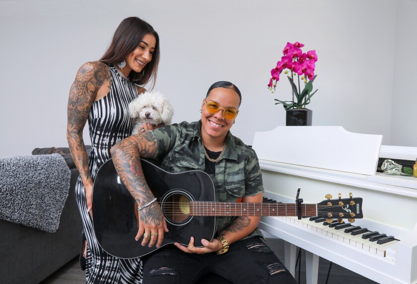 Portrait of singer and musician Celina Graves with her wife, Erica, and their dog, Hope, at their apartment in Escondido.