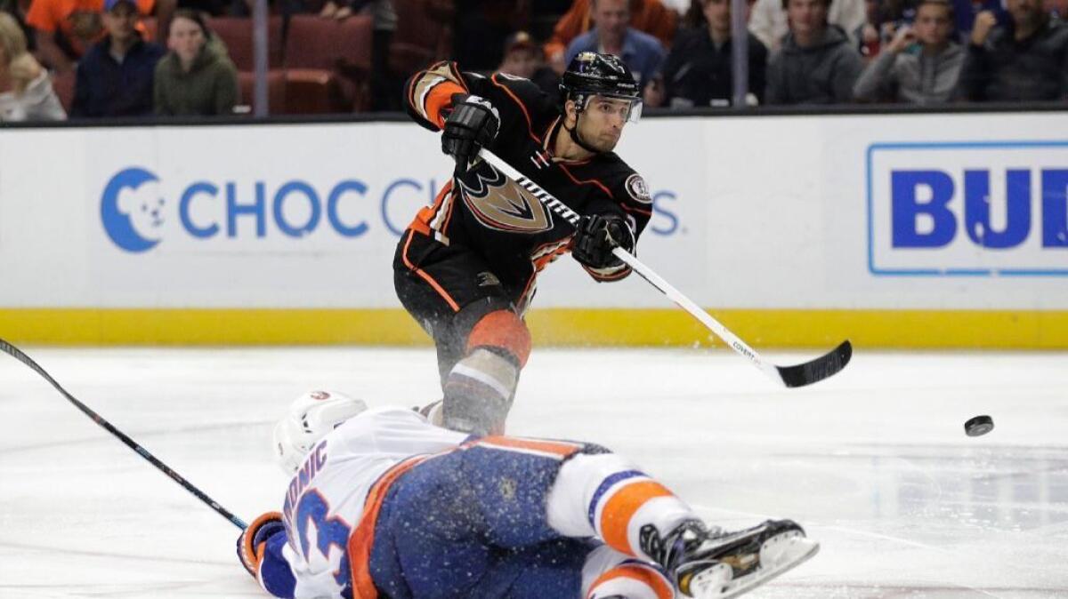 Ducks forward Andrew Cogliano puts a shot on net under pressure from Islanders defenseman Travis Hamonic during the second period of a game on Nov. 22.