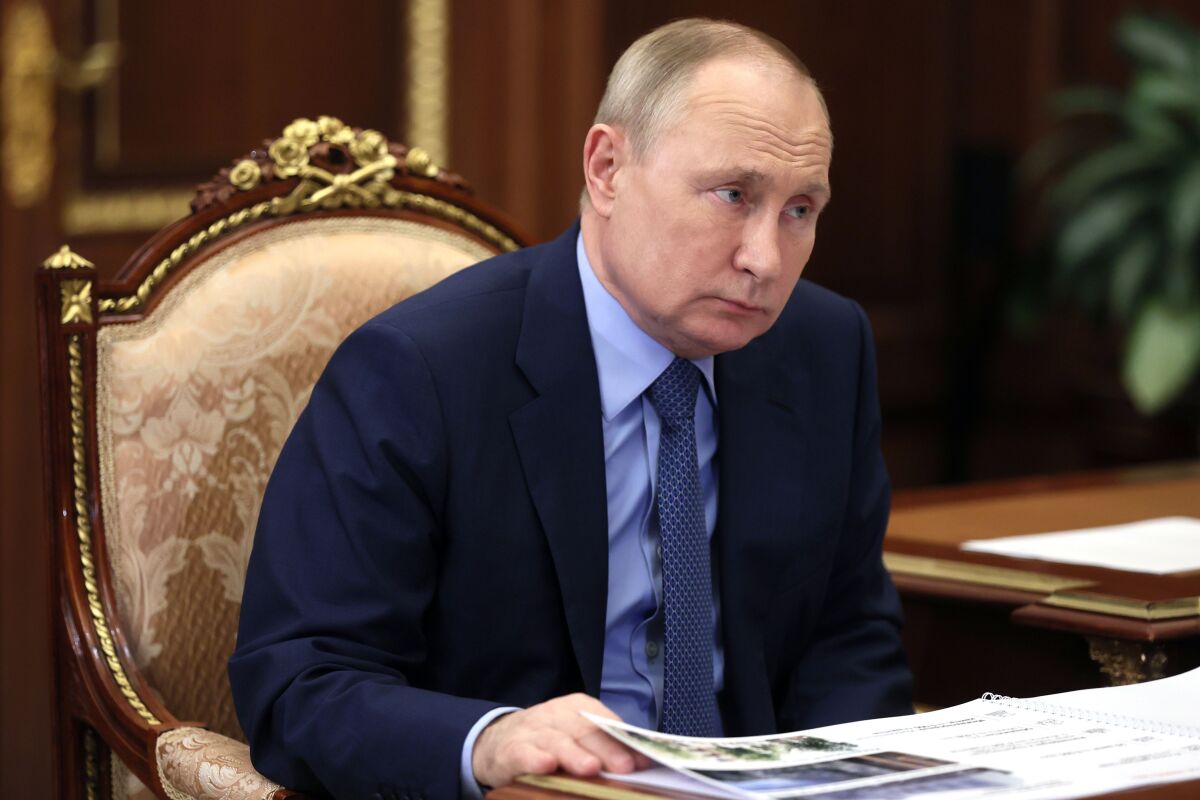 Russian President Vladimir Putin listens during a meeting