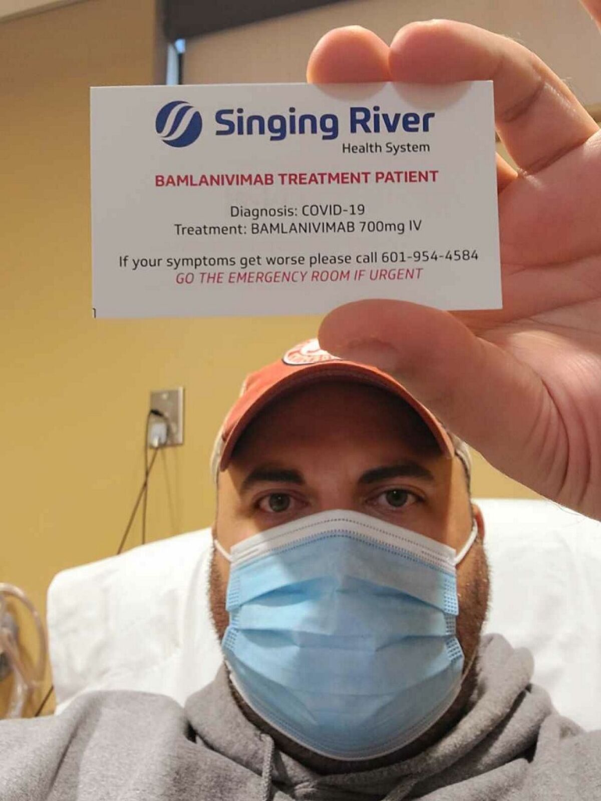 COVID-19 patient Gary Herritz of Pascagoula, Miss., holds a card identifying him as a monoclonal antibody therapy recipient.
