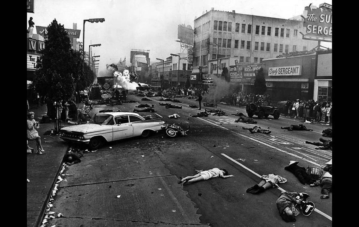 Sunday, Mary 24, 1970: War filmed on Hollywood Blvd. This view of 100 soldiers and civilan victims sprawled amid bursting bombs startled residents along Hollywood Blvd. between Las Palmas and Cherokee Aves early on a Sunday morning. Scene was in a dream-war sequence for the movie Alex in Wonderland. The producer said it was the first time police allowed closing of Hollywood Blvd. for filmmaking. Photo by Don Cormier/Los Angeles Times. For From the Archives.