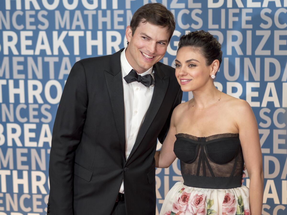 Ashton Kutcher and wife Mila Kunis in formalwear pose for a photo