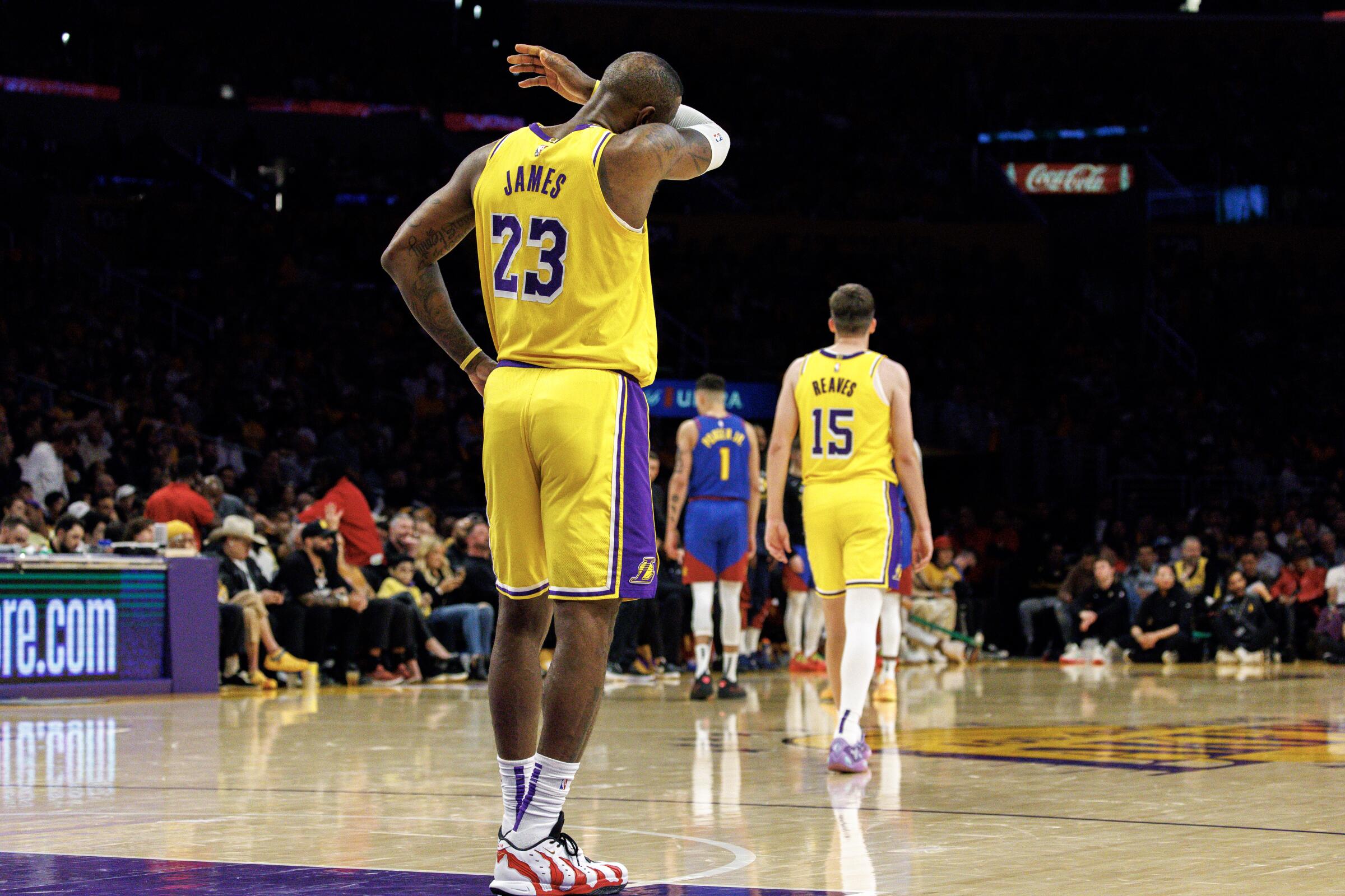 The Lakers' LeBron James wipes sweat from his face in the final moments of Thursday's Game 3 loss to the Nuggets.