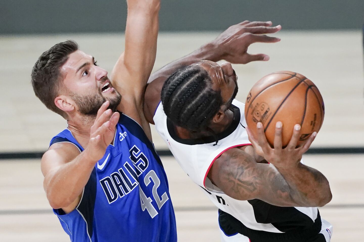 Clipper Kawhi Leonard, right, shoots as he is defended by Dallas Mavericks' Maxi Kleber (42) during the playoff game Friday.