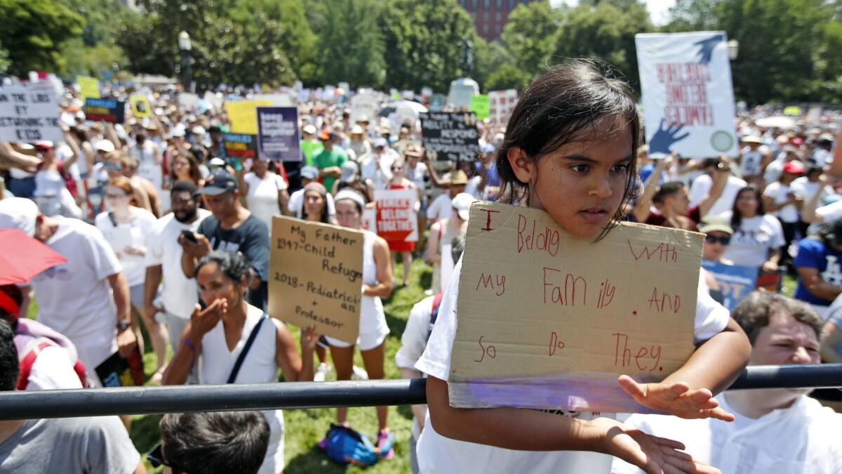Anushur Berger, 8, applauds as activists protest the Trump administration's immigration policy in Lafayette Square across from the White House on Saturday, June 30, 2018.