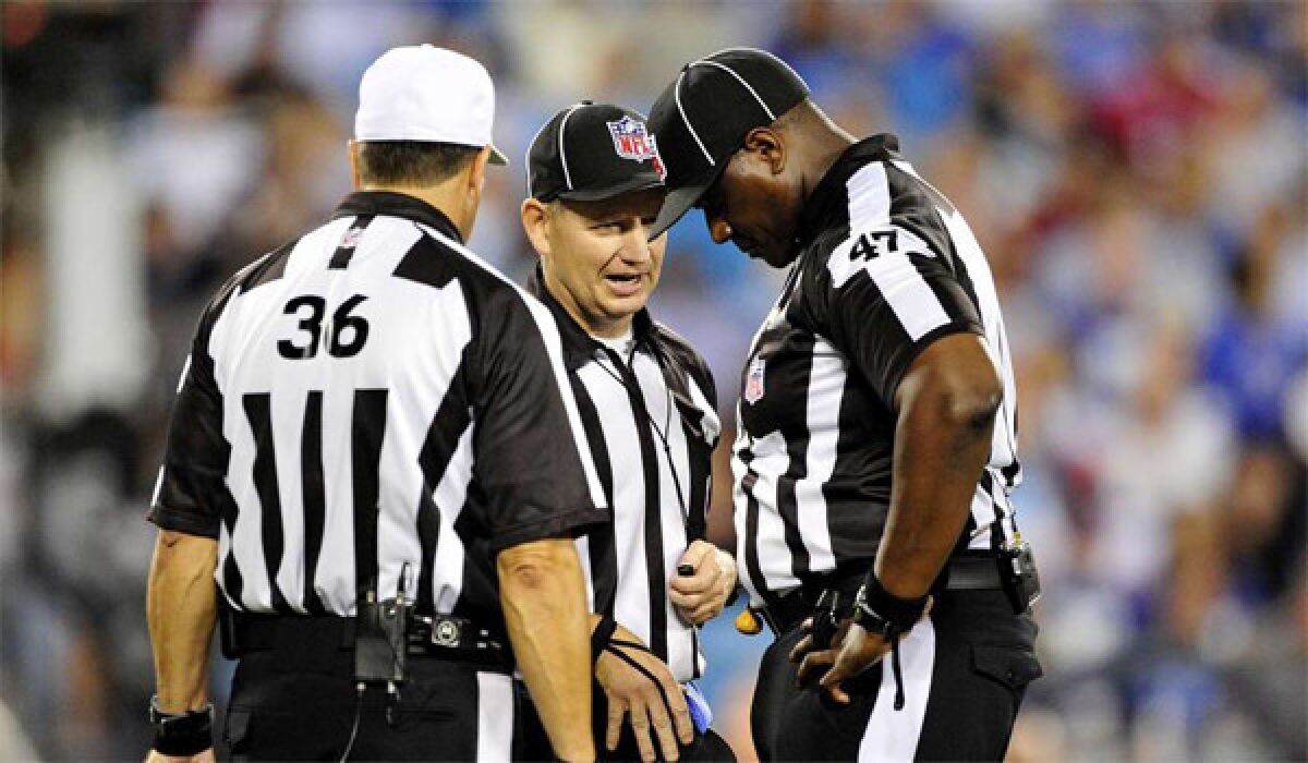 Referees Robert Frazer, left, John Vachon, center, and Lemuel Hawkins, right, confer after throwing a penalty flag during a New York Giants-Carolina Panthers game on Sept. 23, 2012.