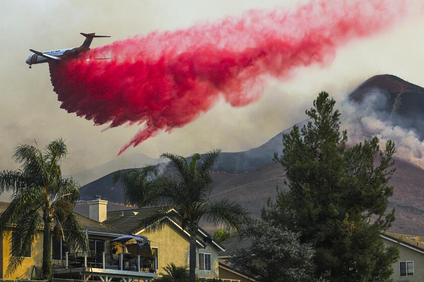 CHINO HILLS, CA - OCTOBER 27: Air tanker makes fire retardant drop behind homes on Tuesday, Oct. 27, 2020 in Chino Hills, CA. (Irfan Khan / Los Angeles Times)