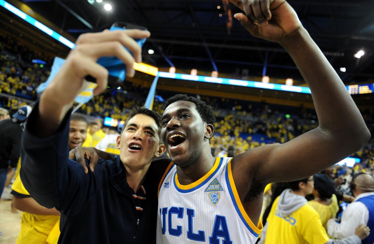 UCLA's Prince Ali takes a selfie with a fan after defeating Kentucky at Pauley Pavillion.