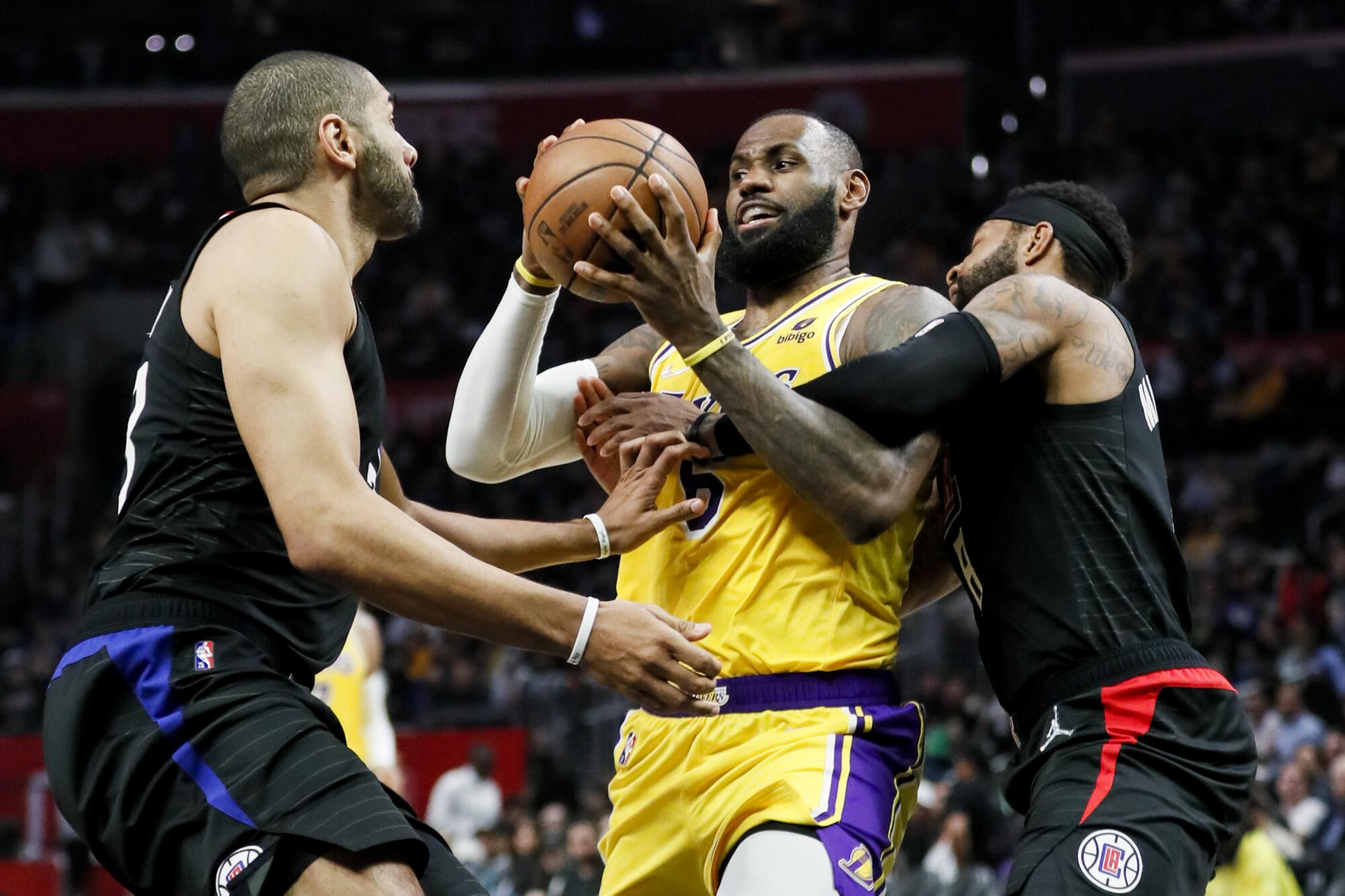 Lakers forward LeBron James gets tangled with Clippers forward Marcus Morris Sr.