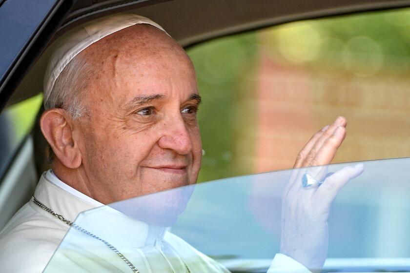 Pope Francis waves as he arrives in Castel Gandolfo to deliver the Angelus prayer.