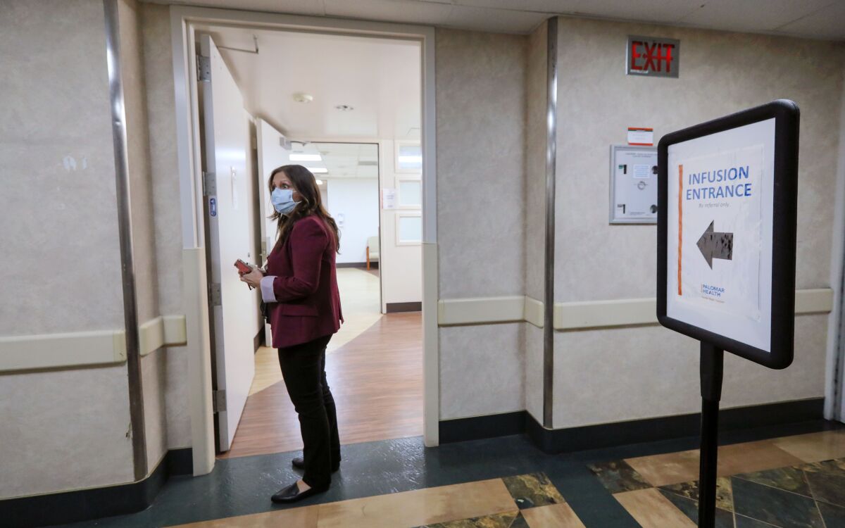 Palomar Health RN Valerie Martinez heads to the monoclonal antibody infusion station at Palomar Medical Center.