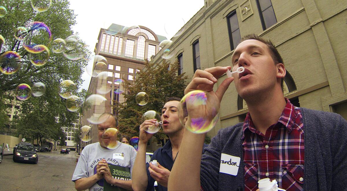 A rally Monday in Milwaukee as gay couples and their supporters board a bus for Chicago for a federal court hearing on same-sex marriage bans.