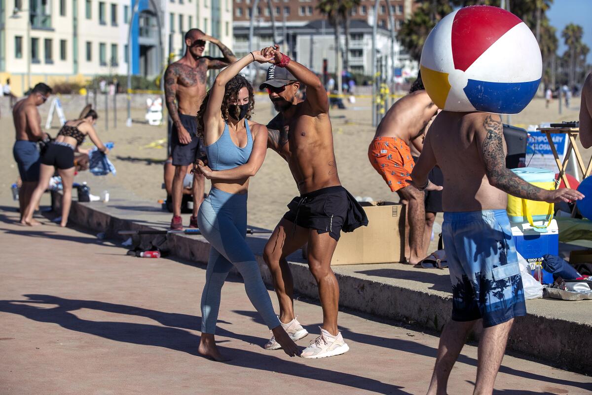 Gabriela Short of West Hollywood and Julio Escobar of Culver City dance to salsa music at the beach in Santa Monica.