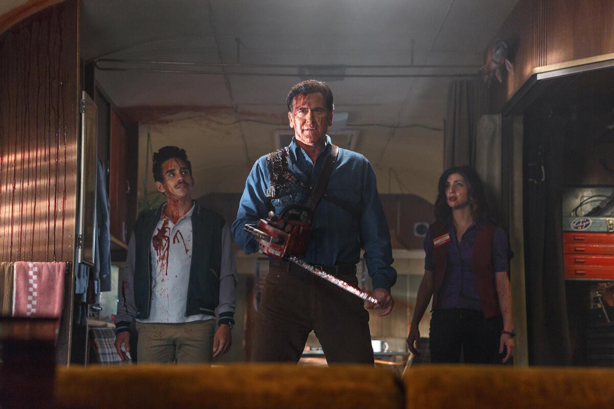 “Evil Dead” newcomers Ray Santiago (as Pablo) and Dana DeLorenzo (as Kelly) join Bruce Campbell (as Ash) for the TV series extension of the longtime horror franchise “Ash Vs. Evil Dead.”