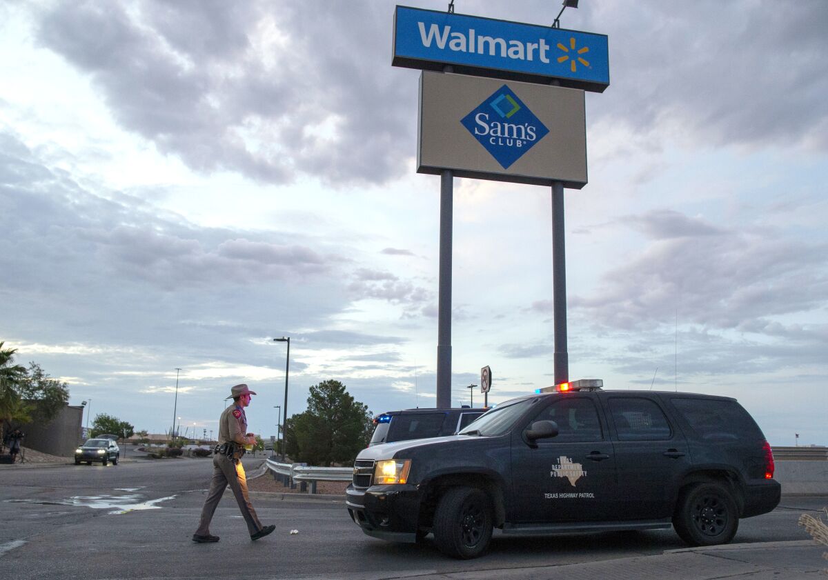 FILE - In this Aug. 4, 2019 file photo, a Texas State Trooper walks back to his car while providing security outside the Walmart store in the aftermath of a mass shooting in El Paso, Texas. A gunman who said he was targeting Mexicans and killed 22 people at a Walmart store in El Paso, Texas, over the summer has been indicted on federal hate crimes charges, a person familiar with the matter told The Associated Press. (AP Photo/Andres Leighton)