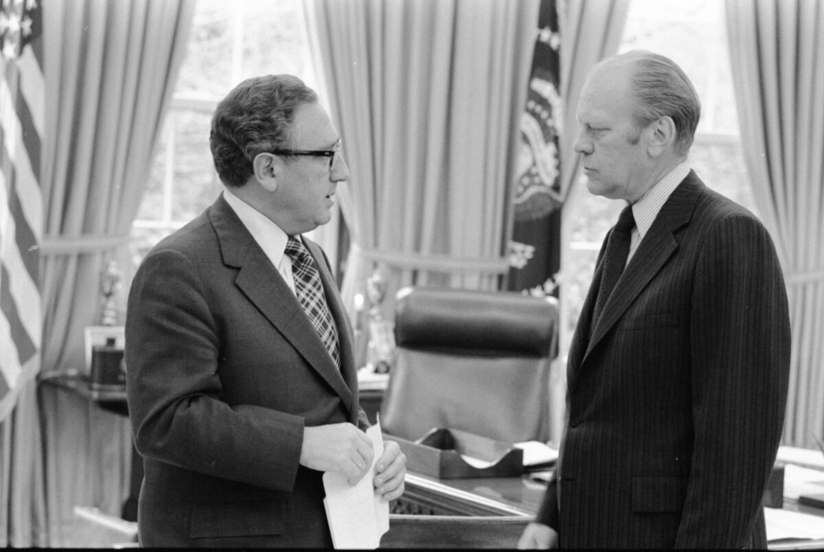 Then-Secretary of State Henry Kissinger, left, talks with President Gerald Ford at the White House in 1975. 