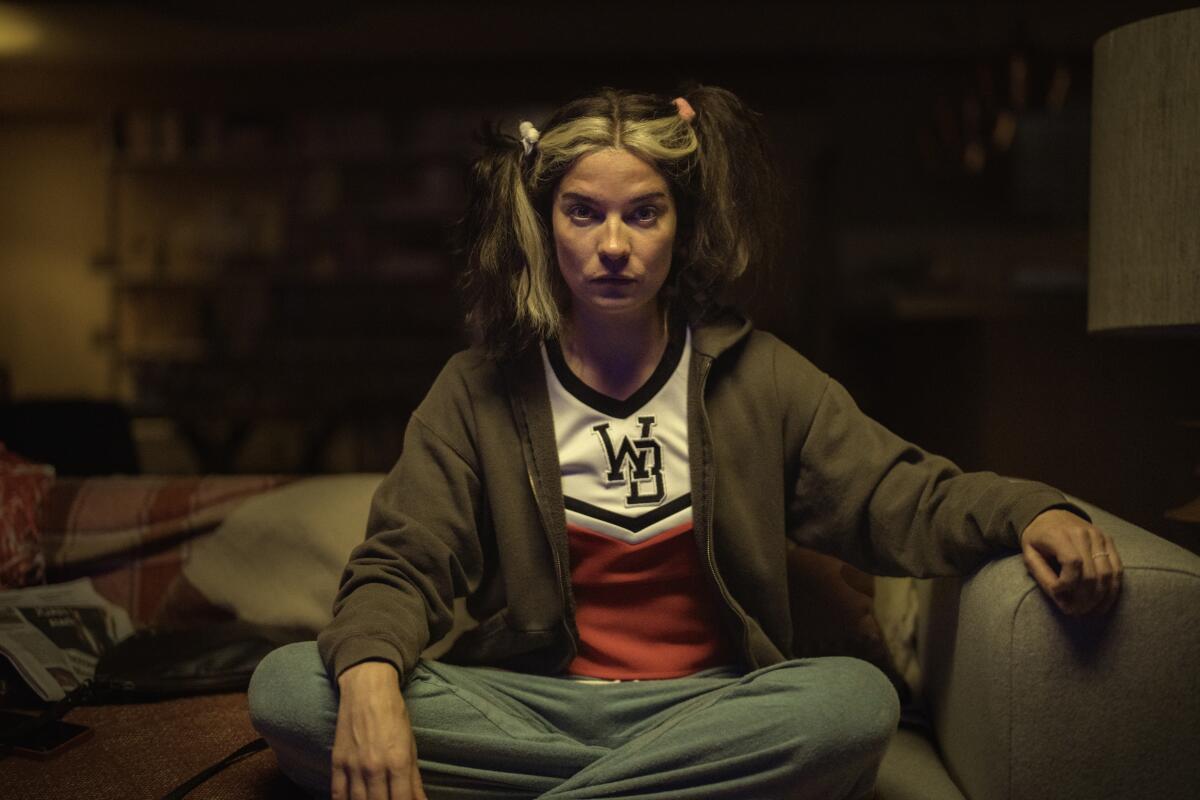 Annie Murphy sits on a couch in "Black Mirror."