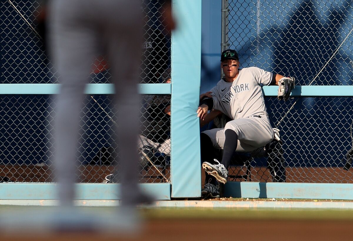 Yankees right fielder Aaron Judge crashes through the outfield fence as he makes an eighth-inning catch.