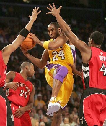 Lakers Kobe Bryant scores past Toronto Raptors Morris Peterson, Fred Jones and Chris Bosh.