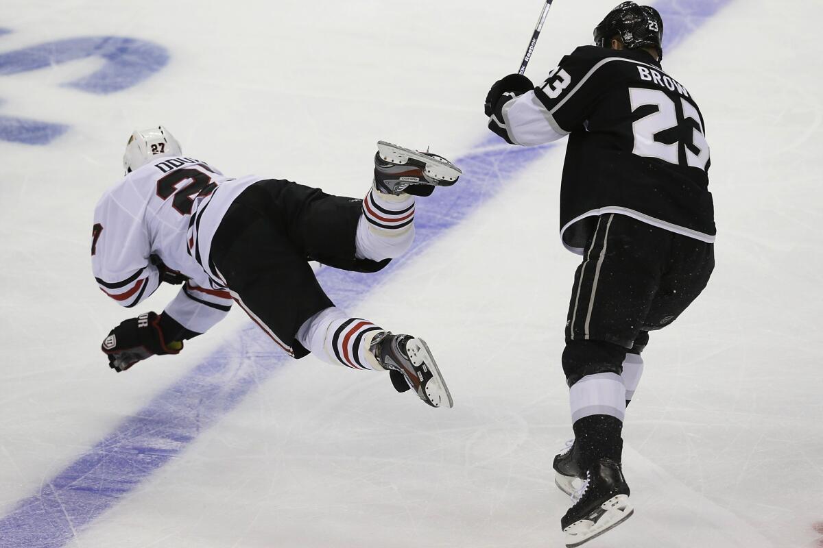 Kings forward Dustin Brown knocks Blackhawks defenseman Johnny Oduya to the ice during the first period of Game 3 of their playoff series.