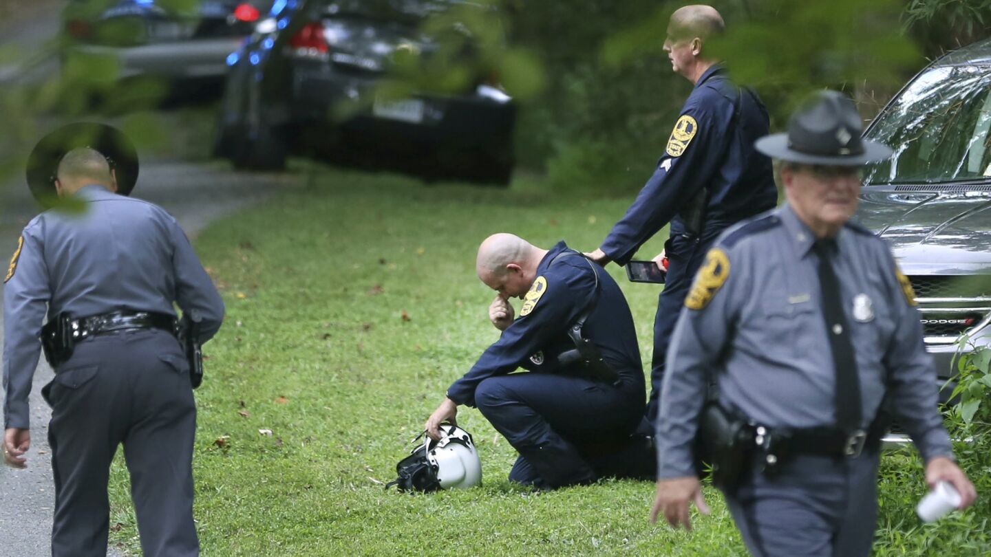 Authorities work near the scene of a deadly helicopter crash near Charlottesville, Va., where white nationalists had gathered for one of their largest rallies in at least a decade.
